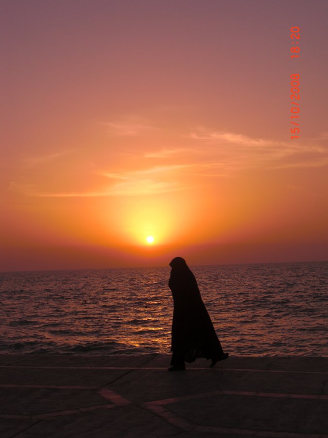 Lady walking against sea sunset, Iran.JPG